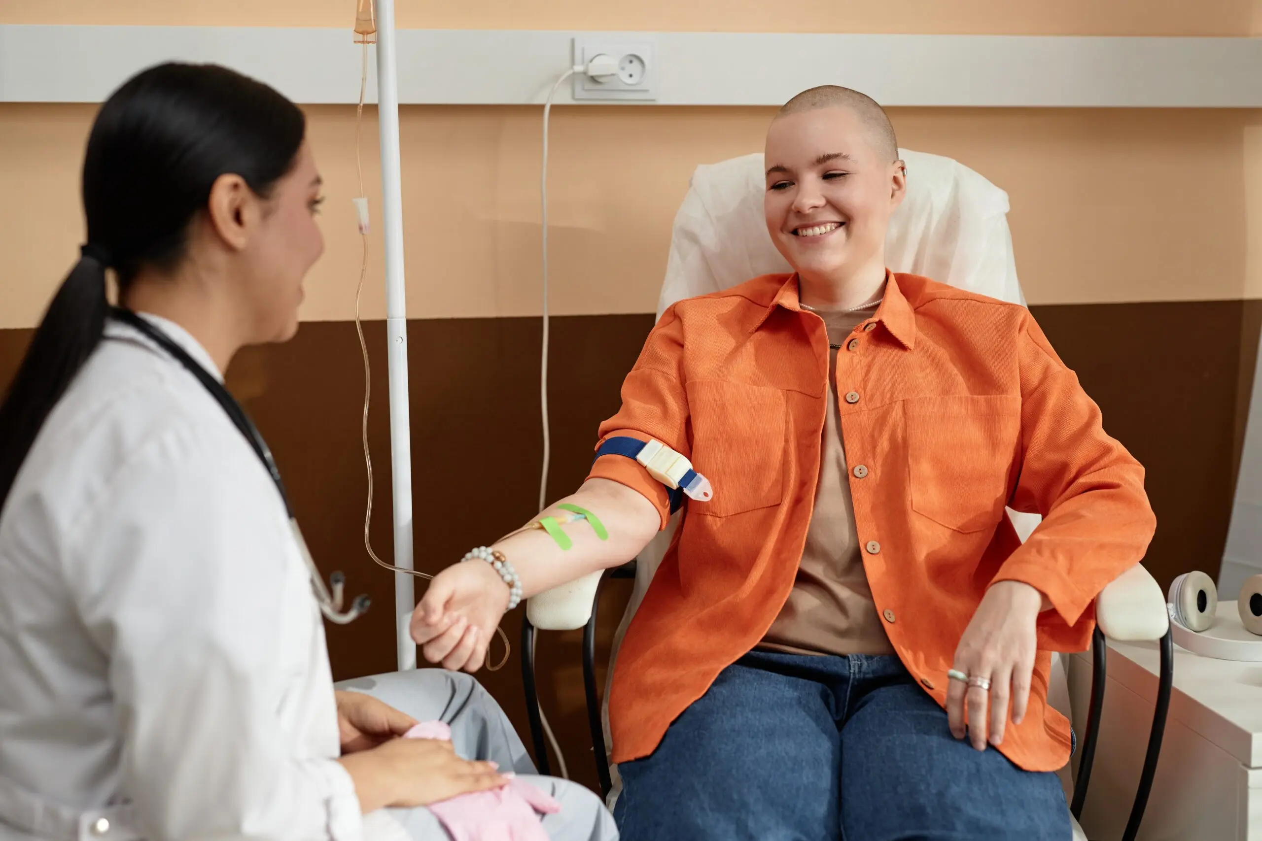 Positive patient talking with nurse during cancer treatment